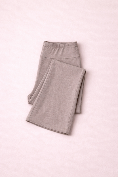 Folded light taupe leggings on a pink background