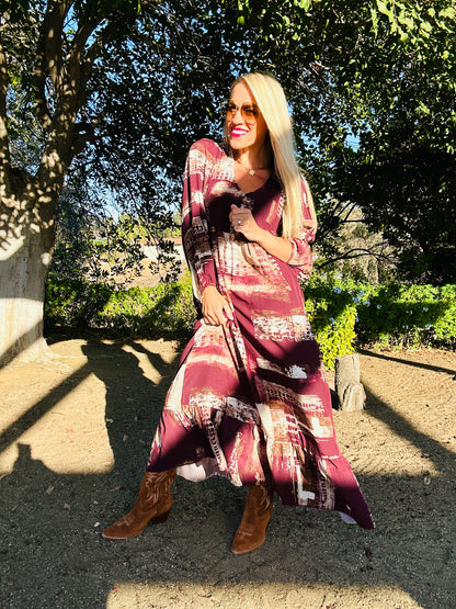 Woman in a patterned dress standing outdoors with trees in the background