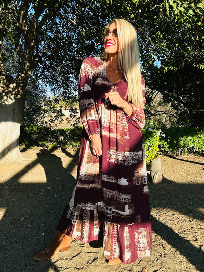 Woman wearing a patterned dress standing outdoors with trees in the background