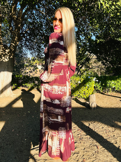Woman wearing a patterned dress standing outdoors with trees in the background