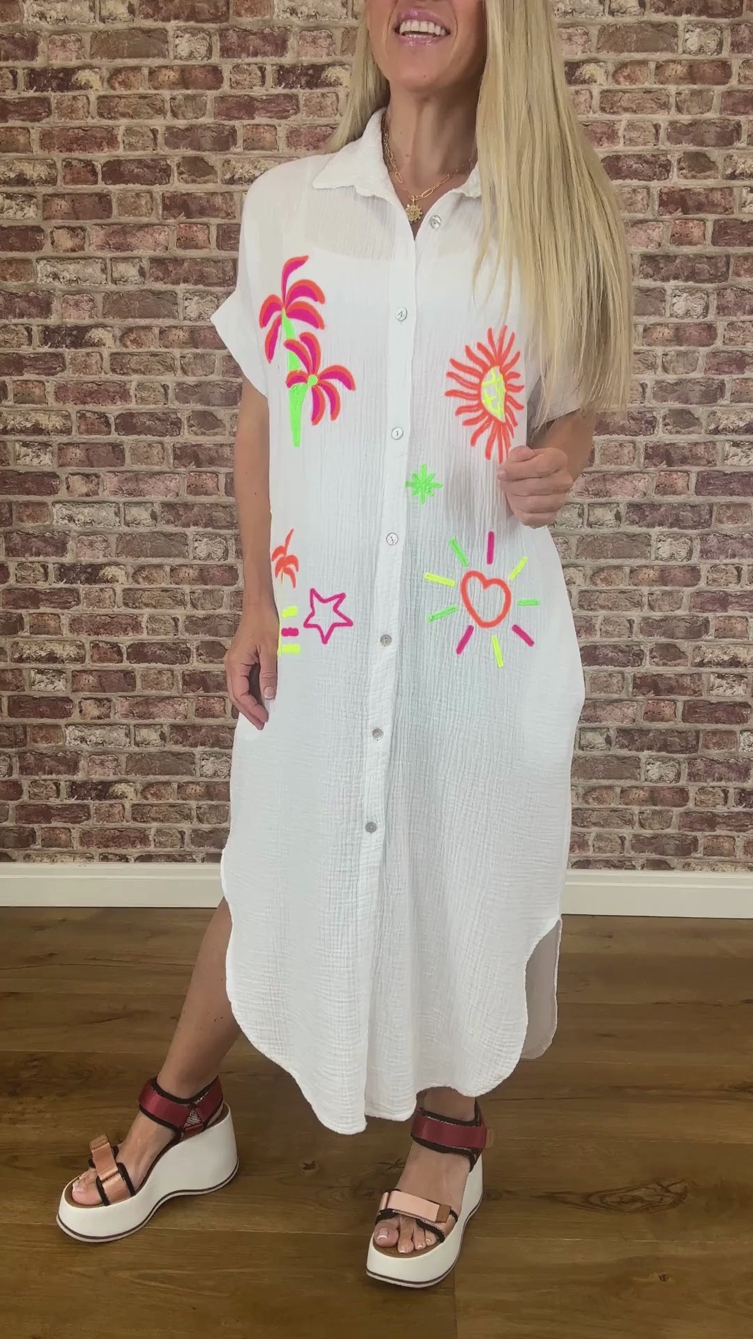 White shirt with colorful designs on a brick wall background