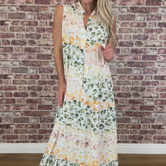 Woman wearing a leopard dress standing against a brick wall.